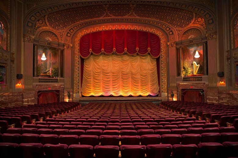 a large theater with red seats