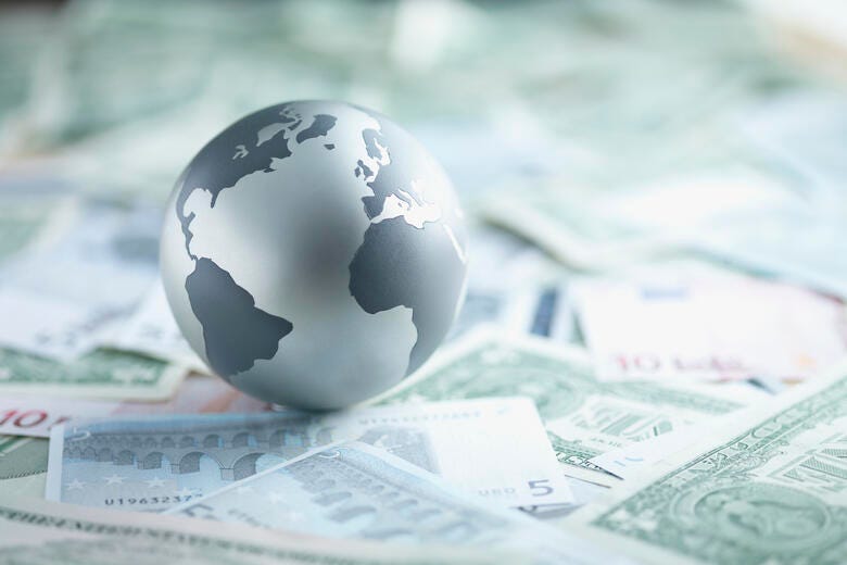 a globe on top of money
