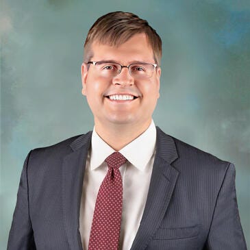 a man wearing glasses and a suit